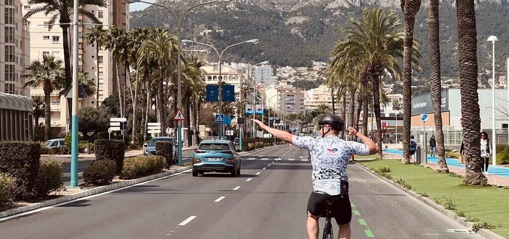 cyclist against a background of palm trees and mountains
