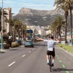 cyclist against a background of palm trees and mountains