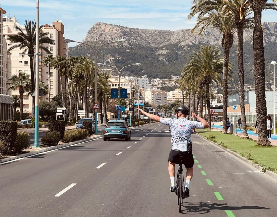 cyclist against a background of palm trees and mountains